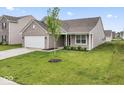 Charming single-story home featuring a two-car garage and a well-manicured lawn at 10107 Camp Creek Way, Indianapolis, IN 46229