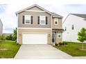 Inviting two-story home boasts a spacious driveway, manicured lawn, and attached two-car garage at 10210 Samerton Ln, Indianapolis, IN 46239