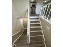 View of finished staircase with newel posts and gray wood grain steps at 10316 Woodhaven Cir, Indianapolis, IN 46229