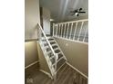 View of finished staircase with newel posts and gray wood grain steps at 10316 Woodhaven Cir, Indianapolis, IN 46229