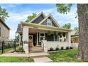 Inviting exterior view with a covered front porch, string lights, and manicured landscaping at 1046 N Hamilton Ave, Indianapolis, IN 46201
