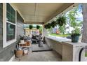 Relaxing covered front porch with stylish outdoor furniture and decorative hanging plants at 1046 N Hamilton Ave, Indianapolis, IN 46201