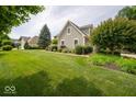 Well-maintained green home with an expansive lawn, mature trees, and inviting curb appeal at 10865 Fairwoods Dr, Fishers, IN 46037