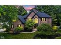 Stunning brick two-story home with a meticulously landscaped lawn and a beautiful arched entryway at 11266 Old Stone Dr, Indianapolis, IN 46236