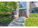 Inviting front entrance with a dark wood door, decorative planters, and lush greenery at 11266 Old Stone Dr, Indianapolis, IN 46236