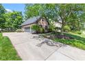 Detached two-car garage with grey doors and a brick exterior with an extra long driveway at 11266 Old Stone Dr, Indianapolis, IN 46236