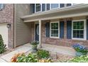 Close-up of the front entrance featuring brickwork, blue shutters, and decorative flowerpots at 11763 Igneous Dr, Fishers, IN 46038