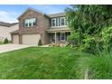 Beautifully landscaped front yard of a two-story home with lush green lawn and mature trees at 11763 Igneous Dr, Fishers, IN 46038