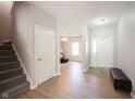 Inviting foyer with hardwood floors, staircase, and access to the living area, showcasing a welcoming entrance at 13829 Black Canyon Ct, Fishers, IN 46038