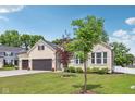 Side view of brick home with well-maintained lawn, garden beds, and an attached two-car garage at 14729 Erica Ln, Carmel, IN 46033