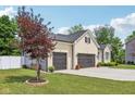Another side view of a brick home with a well-kept lawn, tidy garden beds, and a spacious two-car garage at 14729 Erica Ln, Carmel, IN 46033
