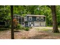 Exterior view of a two-story home with a screened-in porch, nestled among lush trees at 1515 Randall Rd, Indianapolis, IN 46240