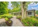 Landscaped front yard features a winding walkway bordered with colorful flowers at 1605 Westlane Rd, Indianapolis, IN 46260