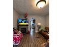 Cozy living room featuring a decorative fireplace, hardwood floors, and an open layout at 1728 N Somerset Ave, Indianapolis, IN 46222