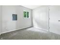 Neutral bedroom featuring carpet floors, a window overlooking green foliage, and a closet at 1933 Tallman Ave, Indianapolis, IN 46218