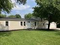 A quaint home with a well-maintained lawn, white trim, and a welcoming front door at 221 N 9Th St, Elwood, IN 46036