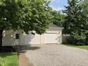 Detached two car garage with white doors, siding, and a gravel driveway at 221 N 9Th St, Elwood, IN 46036