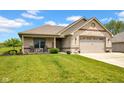 Attractive brick home featuring a cozy front porch with seating and a lush green lawn at 3072 W Glacier Dr, Monrovia, IN 46157