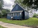 Charming blue home with a well-maintained front yard and mature trees at 3127 E Lynn St, Anderson, IN 46016