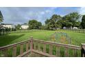 Expansive backyard featuring a large grassy area, a black fence, mature trees, and a play dome at 3610 Homestead Pl, Plainfield, IN 46168