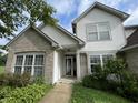 Inviting front entrance with gray brick and white siding, complemented by well-maintained landscaping at 3610 Homestead Pl, Plainfield, IN 46168