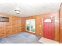 Living room with paneled walls, front door, and natural light from large window at 3965 Alsace Pl, Indianapolis, IN 46226