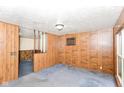 Open living space with paneled walls and carpet, next to split-level stair access at 3965 Alsace Pl, Indianapolis, IN 46226