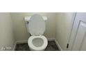 Standard white toilet with a closed lid, located in a modest bathroom with neutral-colored walls at 403 Bagley Ln, Indianapolis, IN 46231