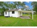 A white home featuring an attached carport in a charming residential neighborhood at 523 Patterson Rd, Columbus, IN 47203