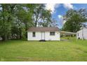 Charming home with a well-maintained lawn, covered carport, and lush trees at 523 Patterson Rd, Columbus, IN 47203