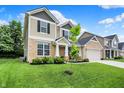Beautifully landscaped two-story home with a two car garage, stone accents, and neutral siding at 5306 Lavender Dr, Plainfield, IN 46168