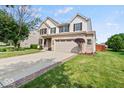 Beautiful two-story home with a well-manicured lawn and mature landscaping with a brick-lined driveway at 5960 Dado Dr, Noblesville, IN 46062