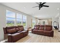 Bright living room featuring two leather couches, hardwood floors, and sun-filled windows at 633 Cowley Dr, Westfield, IN 46074
