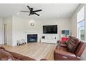 Cozy living room features a fireplace, ceiling fan, and a large television at 633 Cowley Dr, Westfield, IN 46074