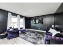 Modern living room with dark accent wall, plush purple seating, and abundant natural light at 6332 Card Blvd, Indianapolis, IN 46221