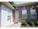 Charming brick entryway with decorative arched windows and a beige front door at 6586 Quail Run, Fishers, IN 46038