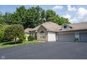Home exterior with stone and siding, complemented by an attached two-car garage at 6586 Quail Run, Fishers, IN 46038