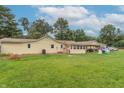 The backyard features a spacious lawn, covered patio, and plenty of space for outdoor activities at 6805 Jackson St, Indianapolis, IN 46241