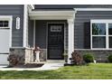 Welcoming front entrance with black door, sidelights, and decorative stone accents at 7153 Sultans Run Ln, Whitestown, IN 46075