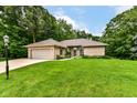 Well-maintained lawn leading to brick home featuring a two-car garage and manicured landscaping at 7175 Scarlet Oak Dr, Noblesville, IN 46062
