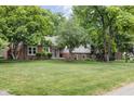 This charming home has a large manicured lawn and mature trees at 7629 Candlewood Ln, Indianapolis, IN 46250