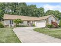 Single-story home features a curved driveway leading to the attached garage and a beautifully landscaped front yard at 792 Nevelle Ln, Carmel, IN 46032