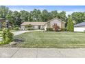Charming single-story home with a well-manicured lawn, stone accents, and an inviting, curved driveway at 792 Nevelle Ln, Carmel, IN 46032