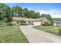 Single-story home features a long curved driveway leading to the attached garage and a beautifully landscaped front yard at 792 Nevelle Ln, Carmel, IN 46032