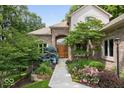 Beautifully landscaped front entrance with mature trees and flowering shrubs at 817 Hickory Way, Noblesville, IN 46062