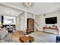 Open-concept living room featuring hardwood floors, modern lighting, and comfortable seating at 906 Berkhamsted Ln, Carmel, IN 46032