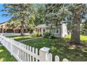 Inviting home featuring mature trees, green lawn, and a classic white picket fence at 917 W Busby St, Lebanon, IN 46052