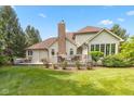 Spacious backyard featuring a deck, a chimney and lovely garden with various plants and flowers at 10455 Trewithen Ln, Carmel, IN 46032