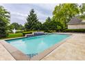 Inviting in-ground pool with stone surround, waterfall feature, and meticulously manicured greenery at 1089 Laurelwood, Carmel, IN 46032