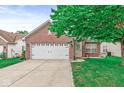 Inviting brick home featuring an attached two-car garage and a well-maintained front yard at 11222 Boston Way, Fishers, IN 46038